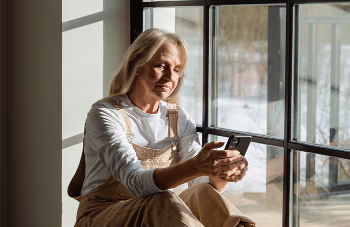vrouw die een vloerisolatie offerte aanvraagt op haar mobiel